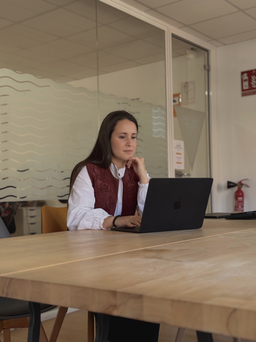 Helena Caro trabajando con su portátil en un espacio de oficina